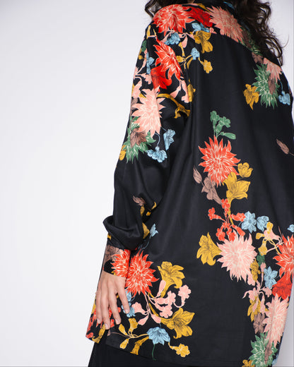 Black garment with colorful floral embroidery on a white background