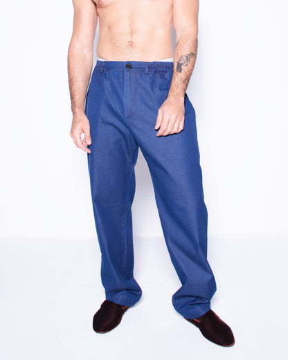 Man wearing blue silky ritorto denim pants on a white background
