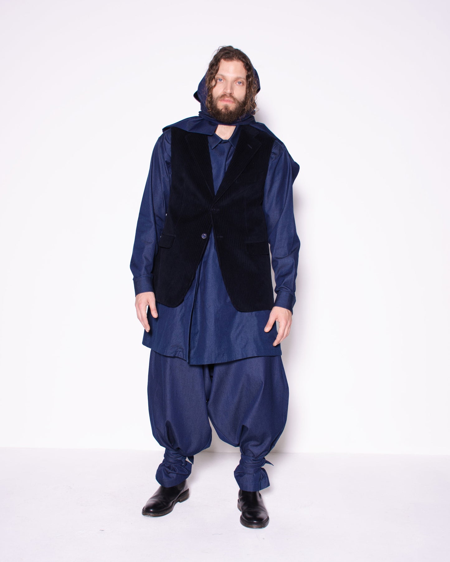 Person wearing a blue outfit with a black vest on a white background