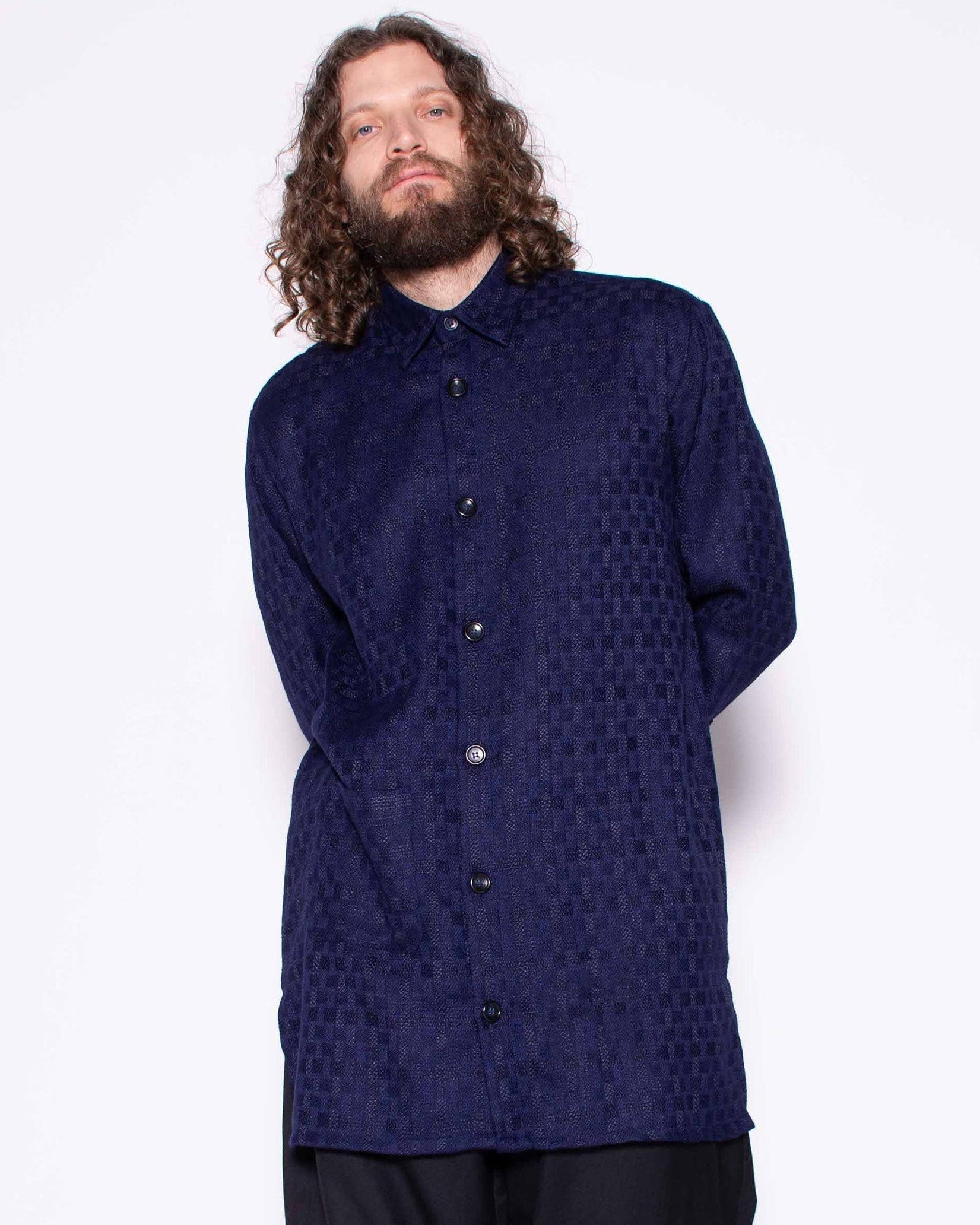 Person wearing a dark blue shirt and black pants on a white background