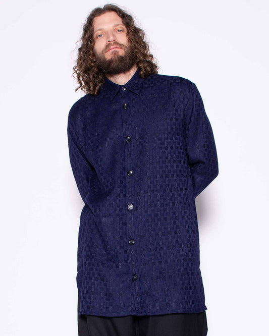 Person wearing a dark blue shirt and black pants on a white background