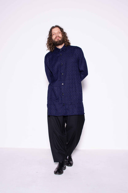 Person wearing a dark blue shirt and black pants on a white background