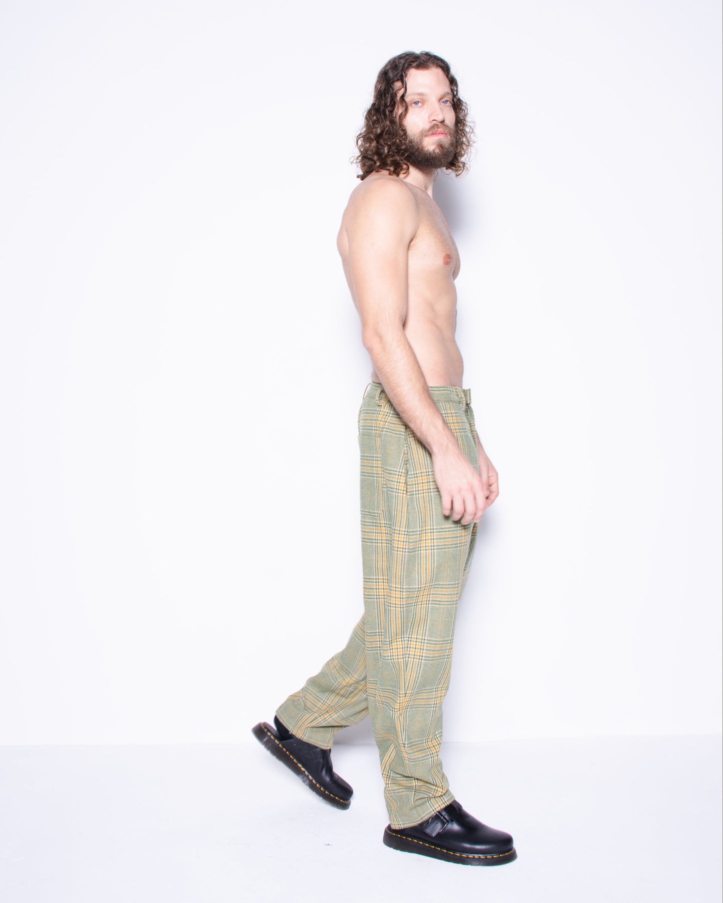 Man wearing green english wool striped  plaid pants on a white 