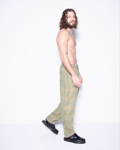 Man wearing green english wool striped  plaid pants on a white 