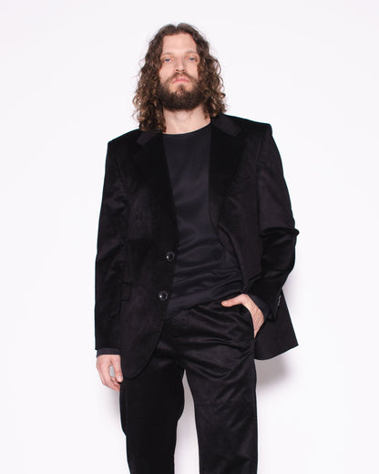 Man wearing a black snake velvet and silk suit on a white background