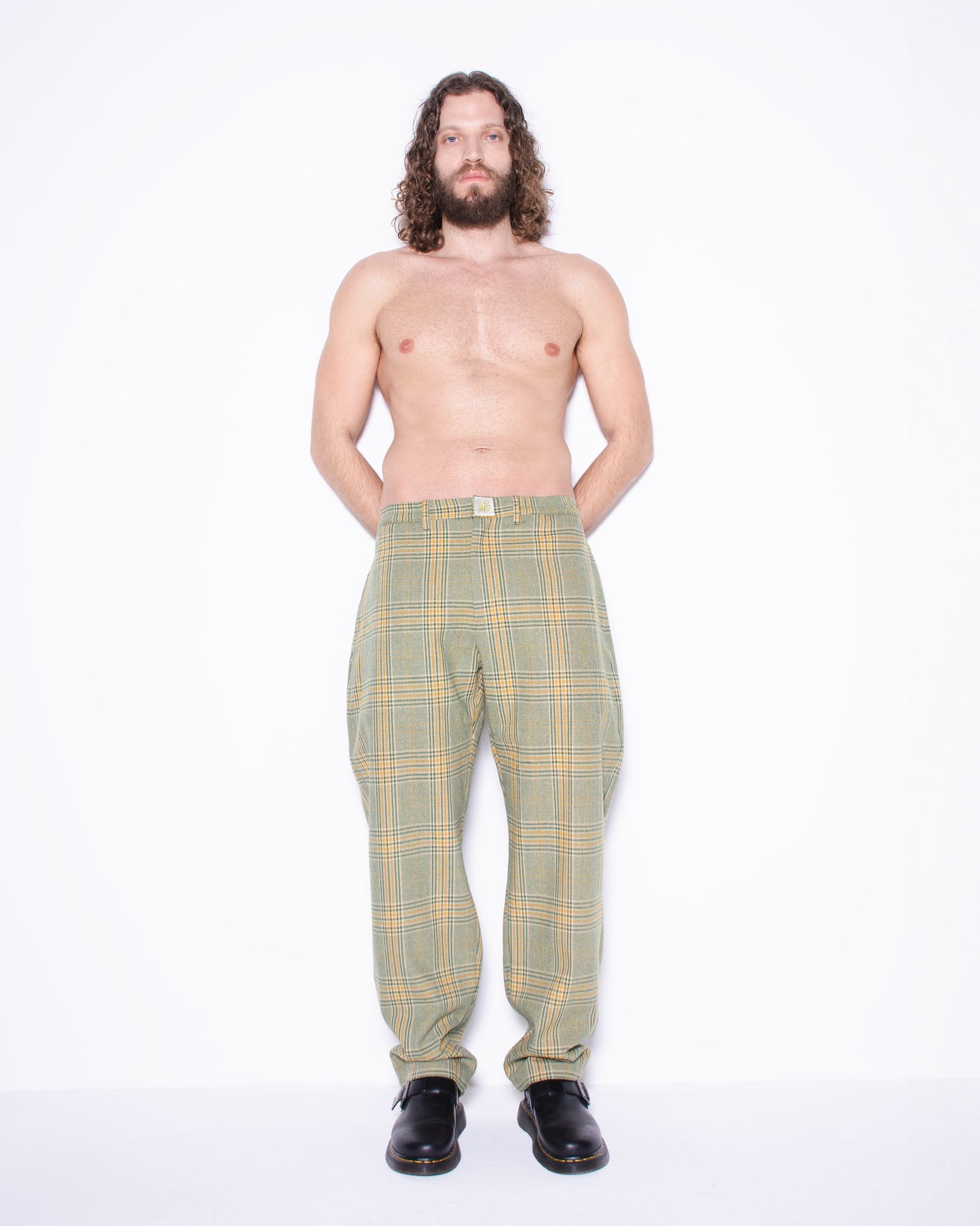 Man wearing green english wool striped  plaid pants on a white background