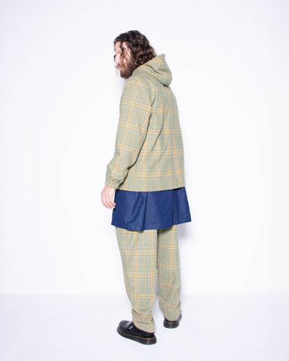  Person wearing green english wool striped  plaid coat and pants with a blue skirt underneath on a white background