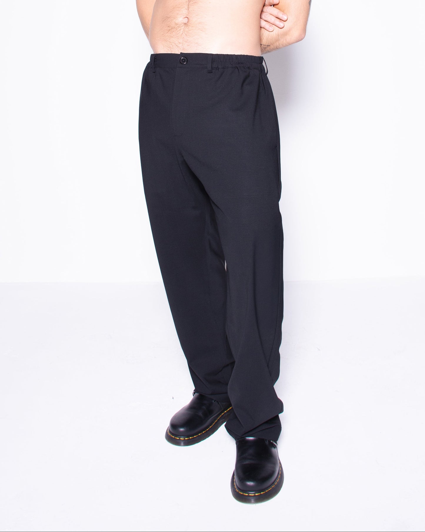 Man wearing black italian wool pants on a white background