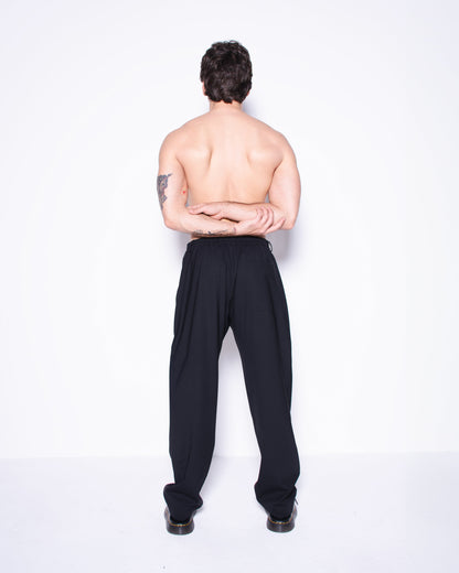 Man wearing black italian wool pants on a white background