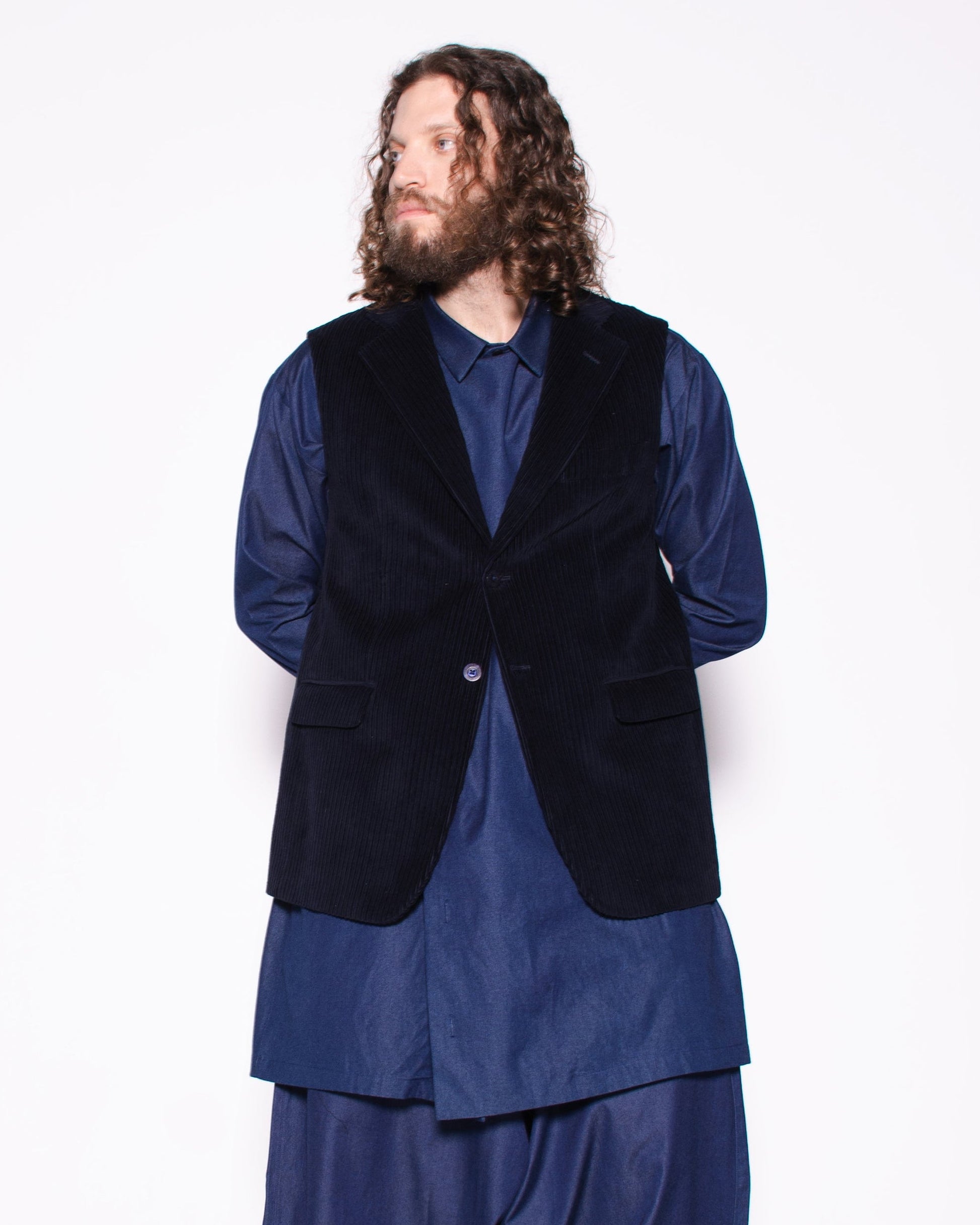 Person wearing a blue outfit with a black vest on a white background