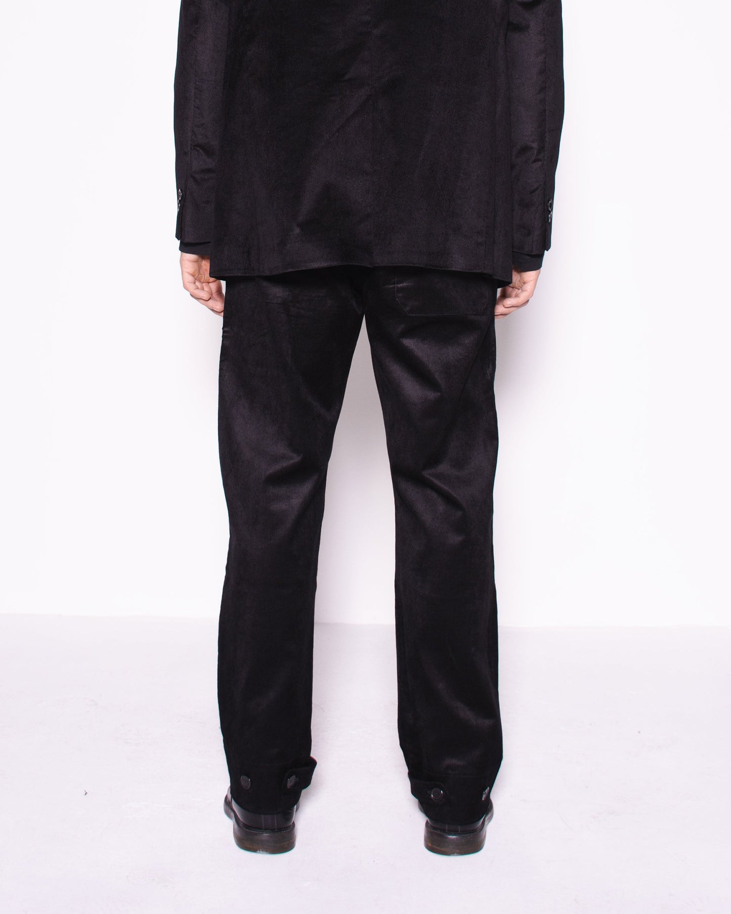 Man wearing a black snake velvet and silk suit on a white background