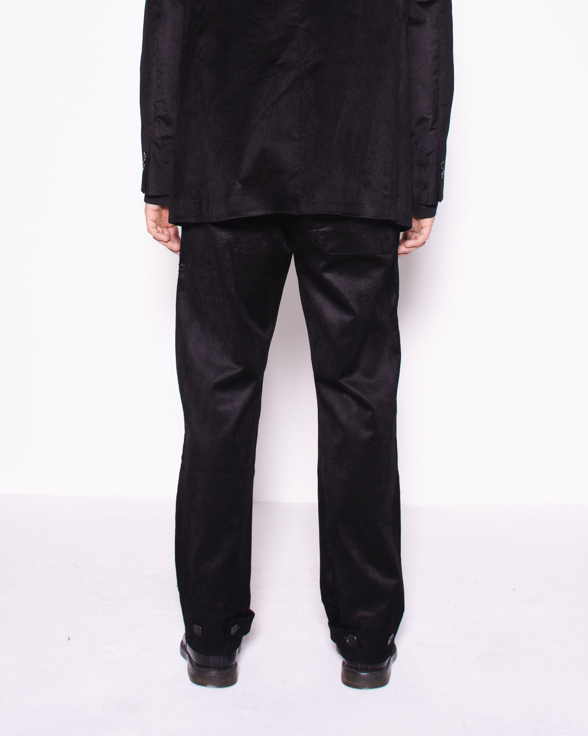 Man wearing a black snake velvet and silk suit on a white background