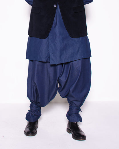 Person wearing a blue outfit with a black vest on a white background