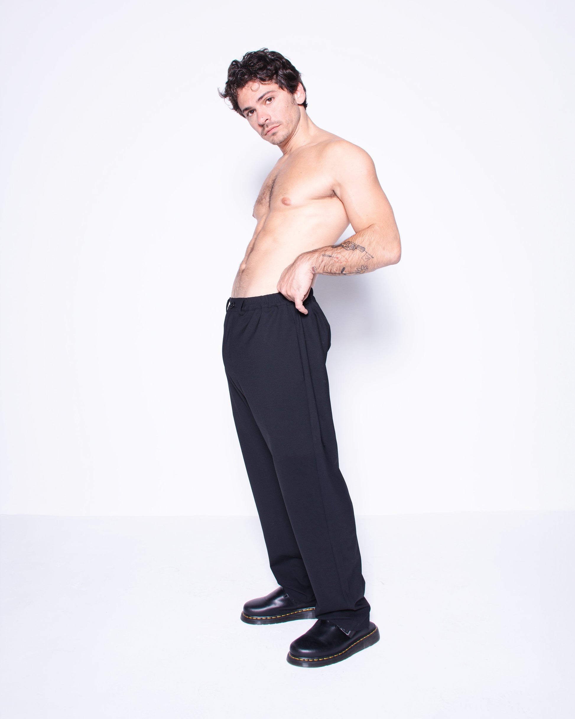 Man wearing black italian wool pants on a white background